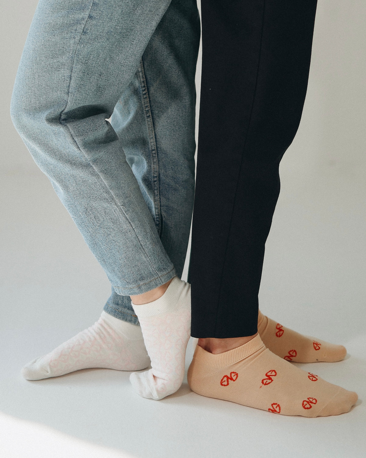 GAILESH fashion socks styled on two people, showing white and beige ankle socks with signature geometric patterns.